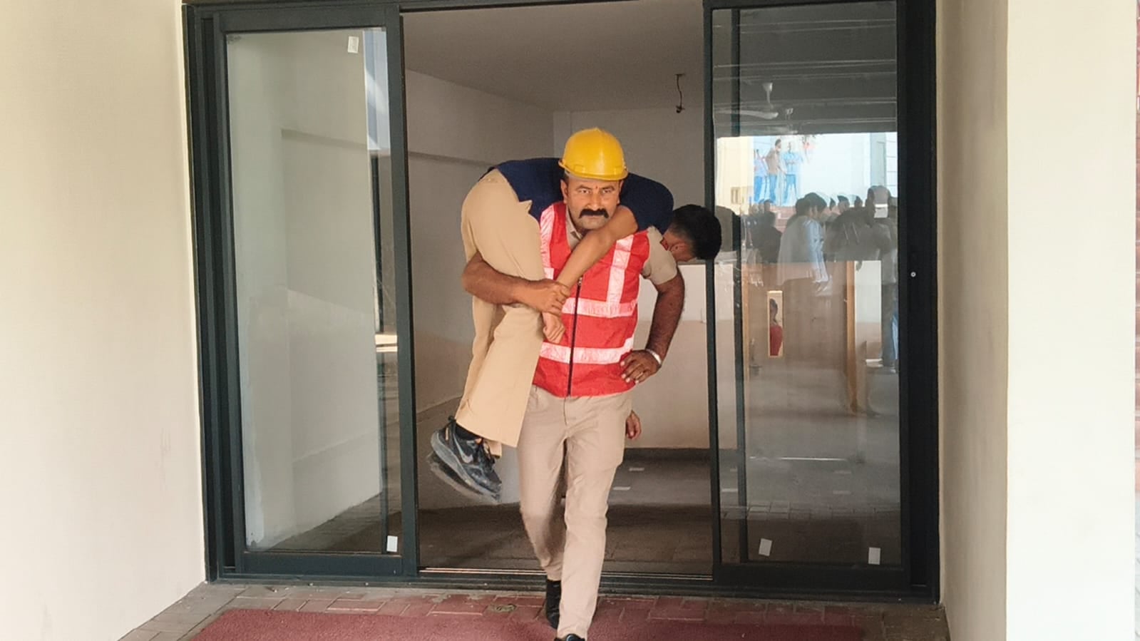 मॉक ड्रिल के दौरान युवक को रेस्क्यू कर सुरक्षित स्थान पर लेकर आती रेडक्रॉस की टीम। संवाद