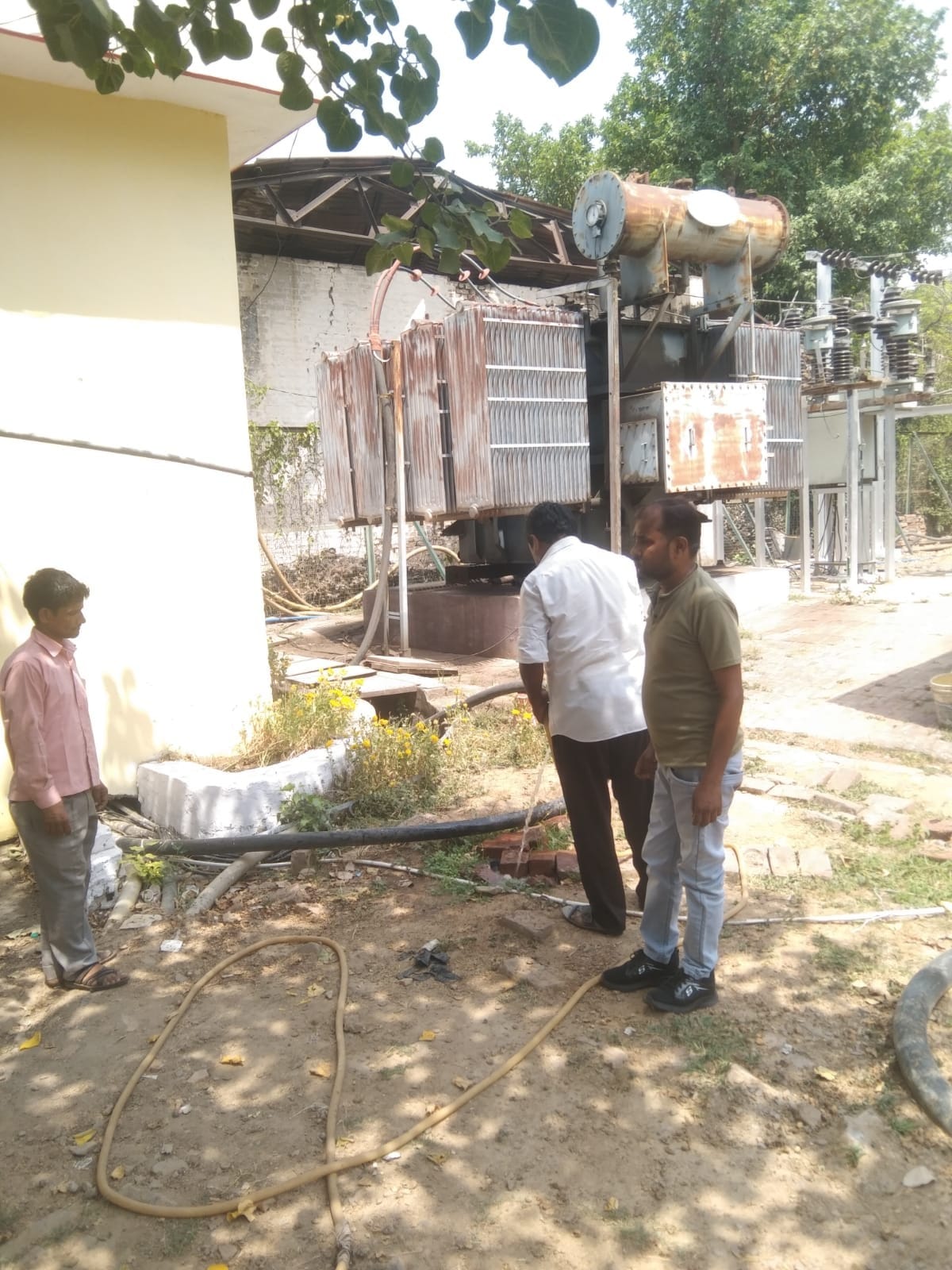 डीएम कालोनी में ट्रांसफार्मर में लोड बढ़ाते बिजली कर्मी। संवाद