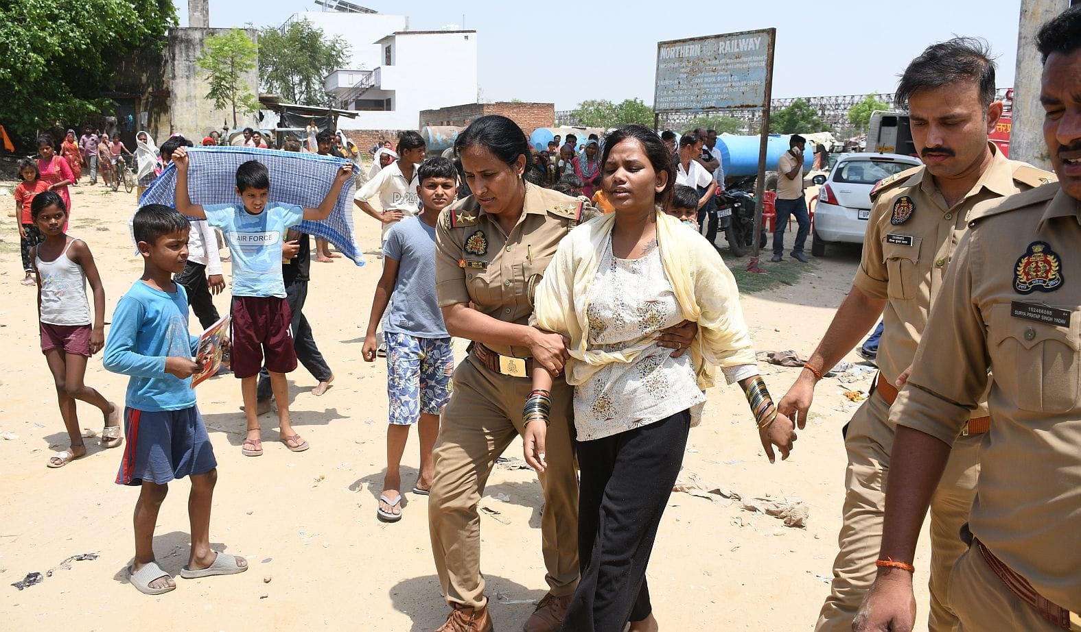 महिला को पानी की टंकी से उतारती पुलिस व मौजूद भीड़।