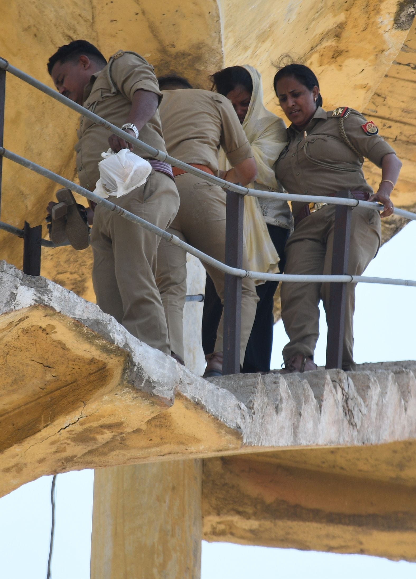 महिला को पानी की टंकी से उतारती पुलिस व मौजूद भीड़।