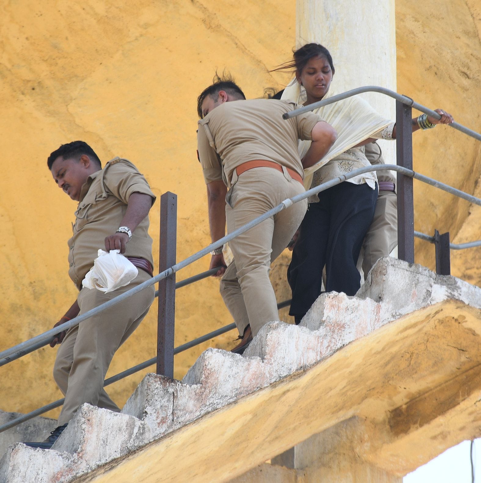 महिला को पानी की टंकी से उतारती पुलिस व मौजूद भीड़।