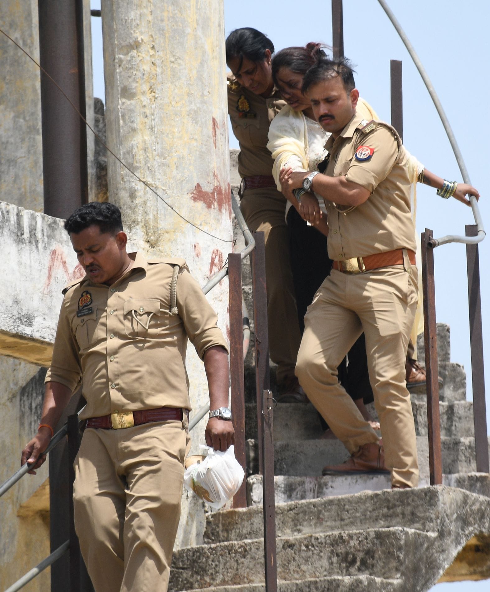 महिला को पानी की टंकी से उतारती पुलिस व मौजूद भीड़।