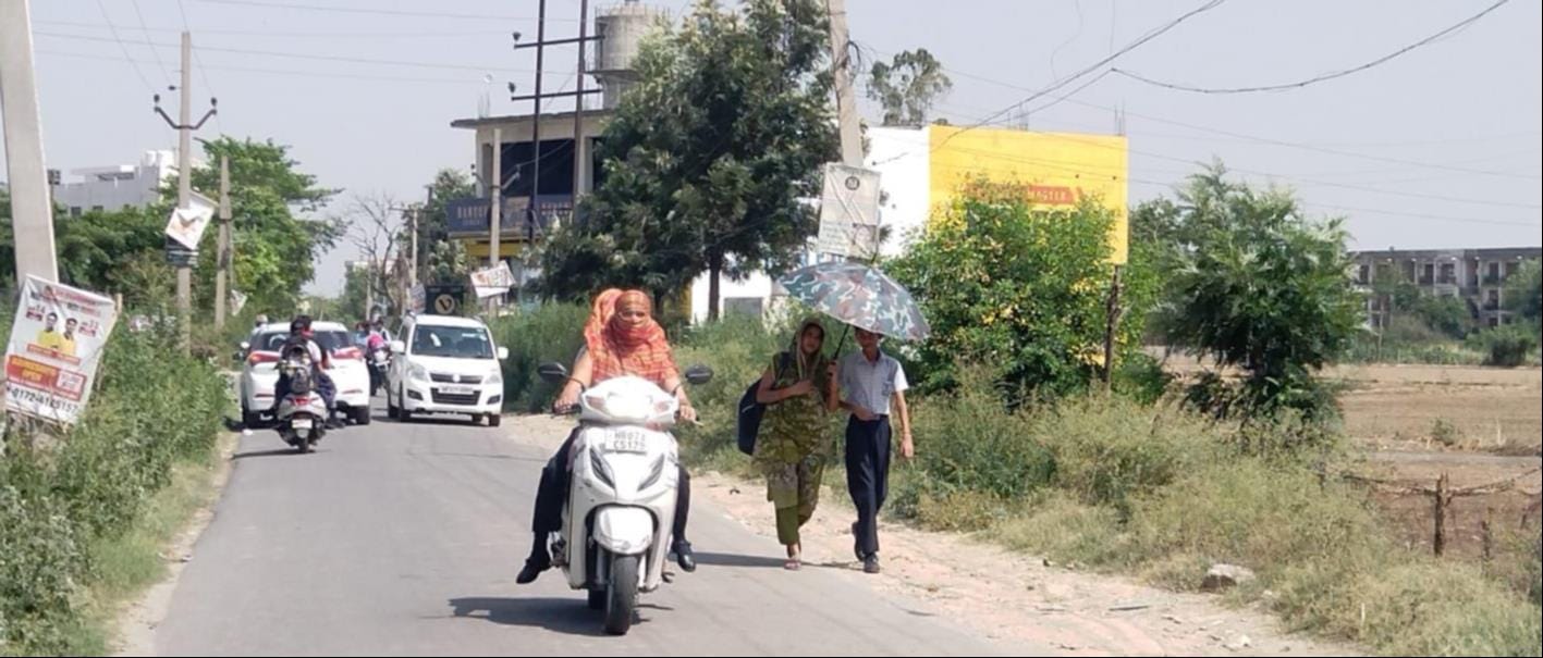 कुरुक्षेत्र। भयंकर गर्मी व लू से बचने के लिए मुहं पर दुपट्टा बांधकर स्कूटी चलाती व धूप से बचने 