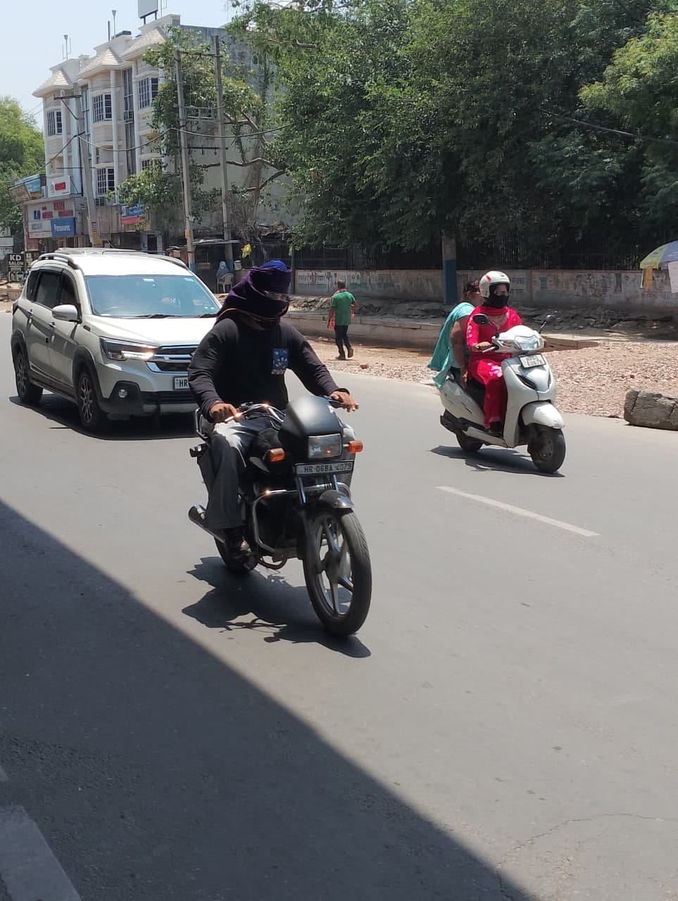कड़ी धूप में सिर पर चुन्नी ढककर जाते युवतियां। संवाद