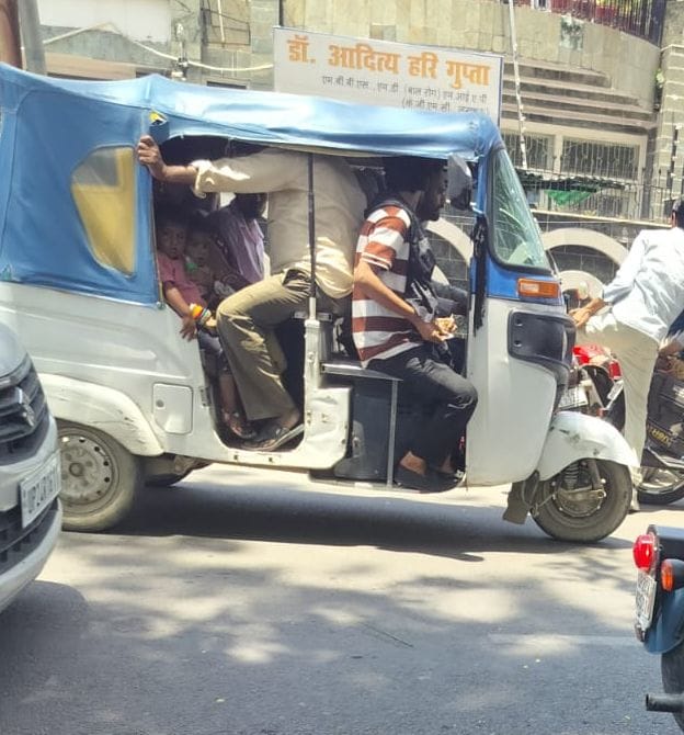 पुलिस लाइन से चौराहा से सवारियों को लटकाकर  ले जाता आॉटो चालक । संवाद