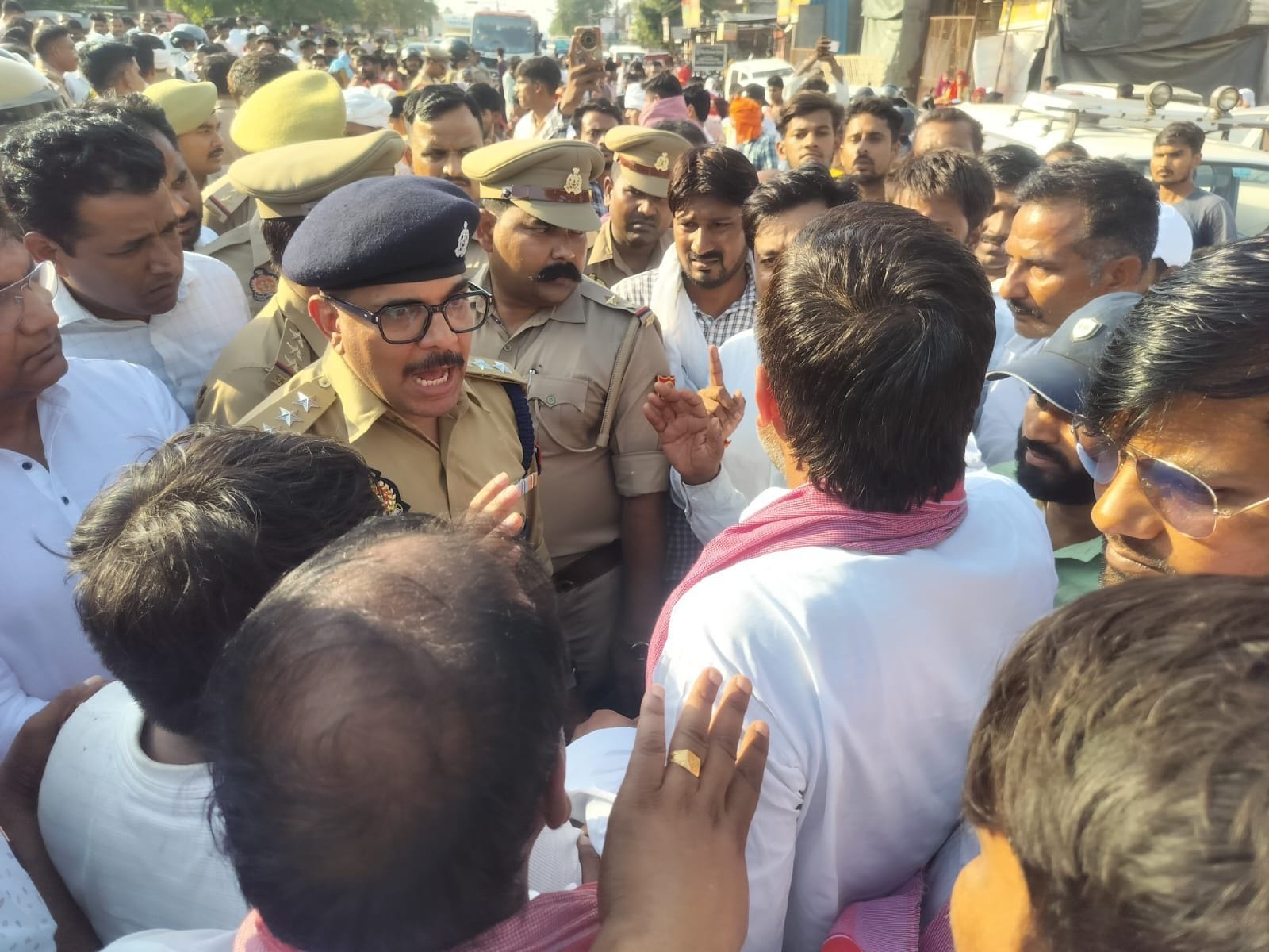 विजय यादव की मौत पर छठामील चौराहे पर शव रखकर प्रदर्शन करते लोग, प्रदर्शनकारियों को समझाते पुलि