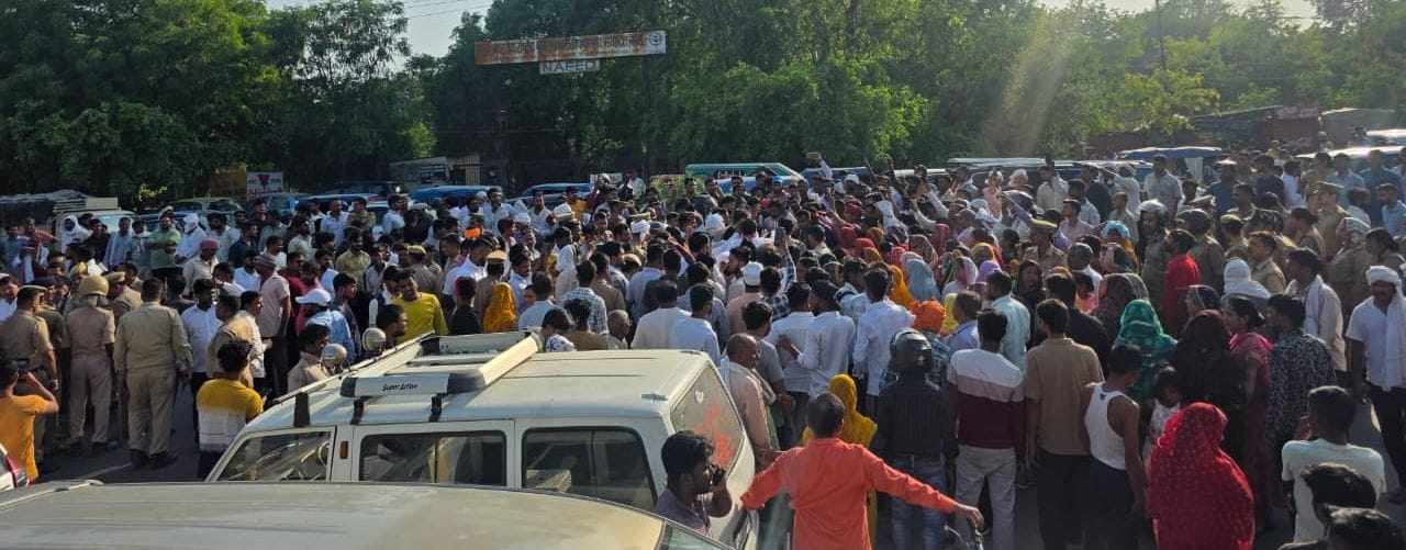 विजय यादव की मौत पर छठामील चौराहे पर शव रखकर प्रदर्शन करते लोग, प्रदर्शनकारियों को समझाते पुलि