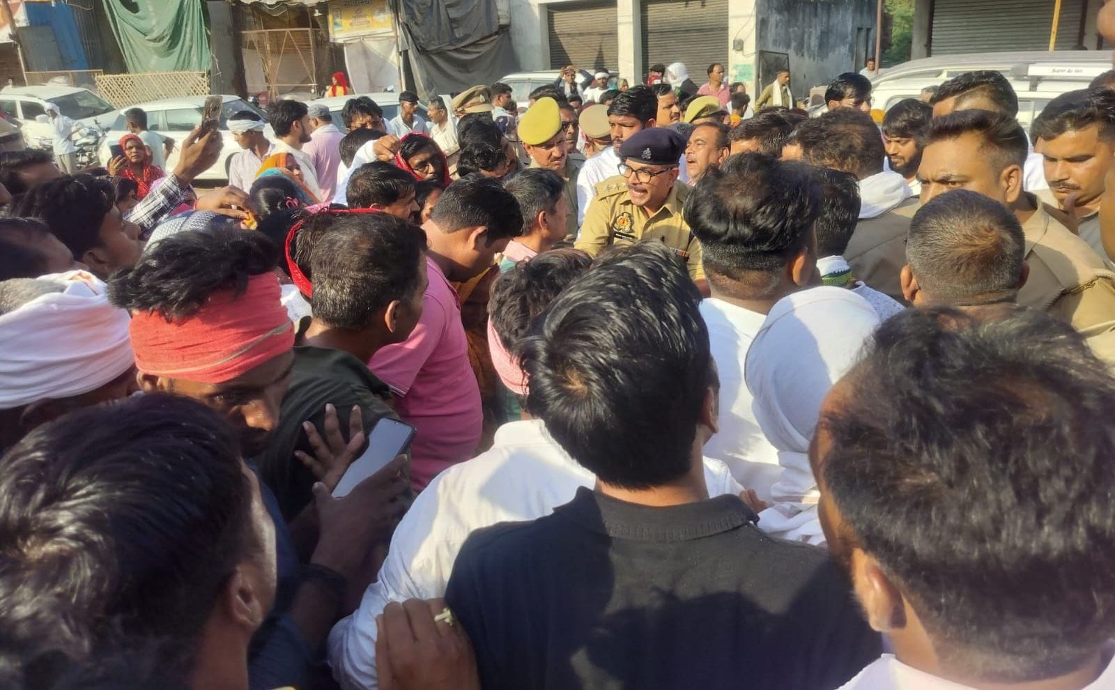 विजय यादव की मौत पर छठामील चौराहे पर शव रखकर प्रदर्शन करते लोग, प्रदर्शनकारियों को समझाते पुलि