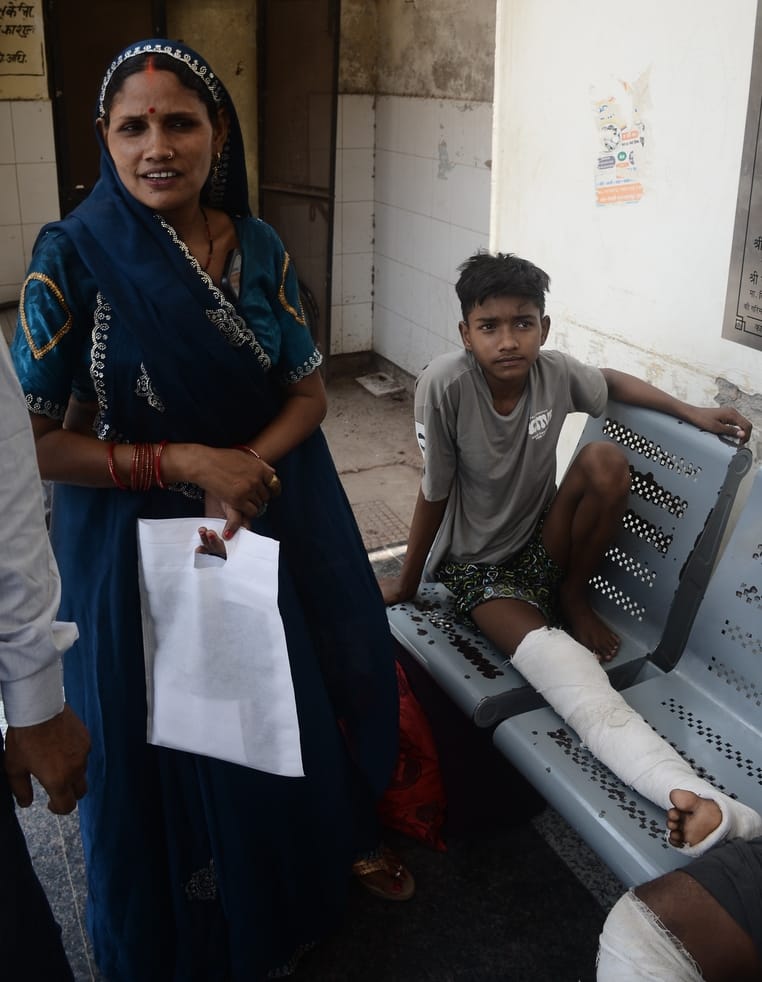 मेडिकल कॉलेज में स्ट्रेचर न मिला तो मां को गोद में उठाकर ओपीडी में लेकर जाता युवक। संवाद