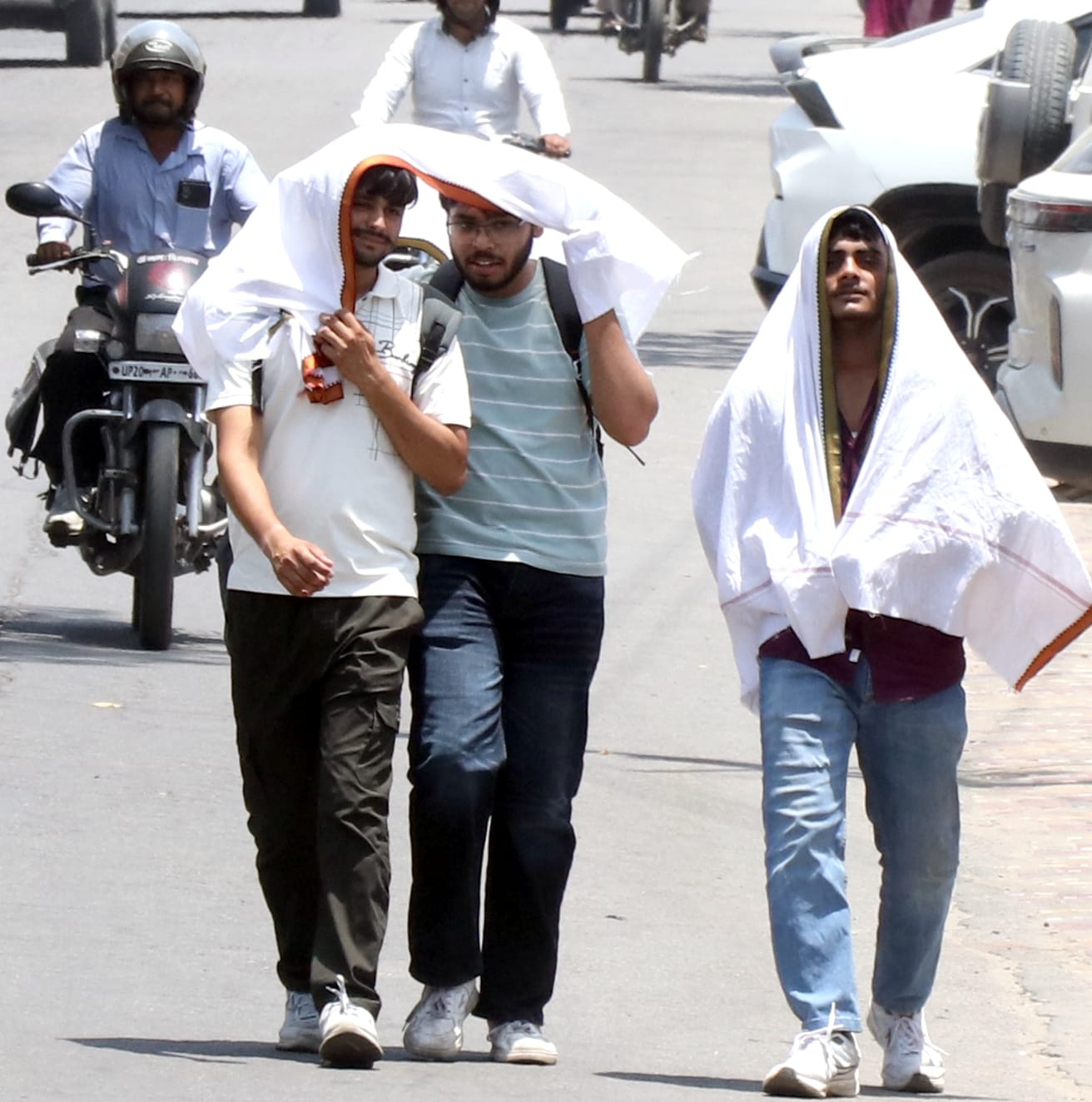 हाय ये गर्मी। बिजनौर में भीषण गर्मी से बचने के लिए दुपट्टा ओढ़कर जाती युवतियां। संवाद