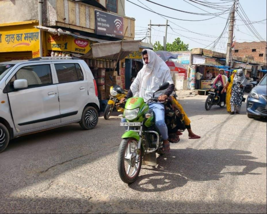 तेज धूप से बचाव के लिए सिर को कपड़े से ढककर जीटी रोड़ से गुजरते लोग। संवाद तेज धूप से बचाव के लिए सिर को कपड़े से ढककर जीटी रोड़ से गुजरते लोग। संवाद
