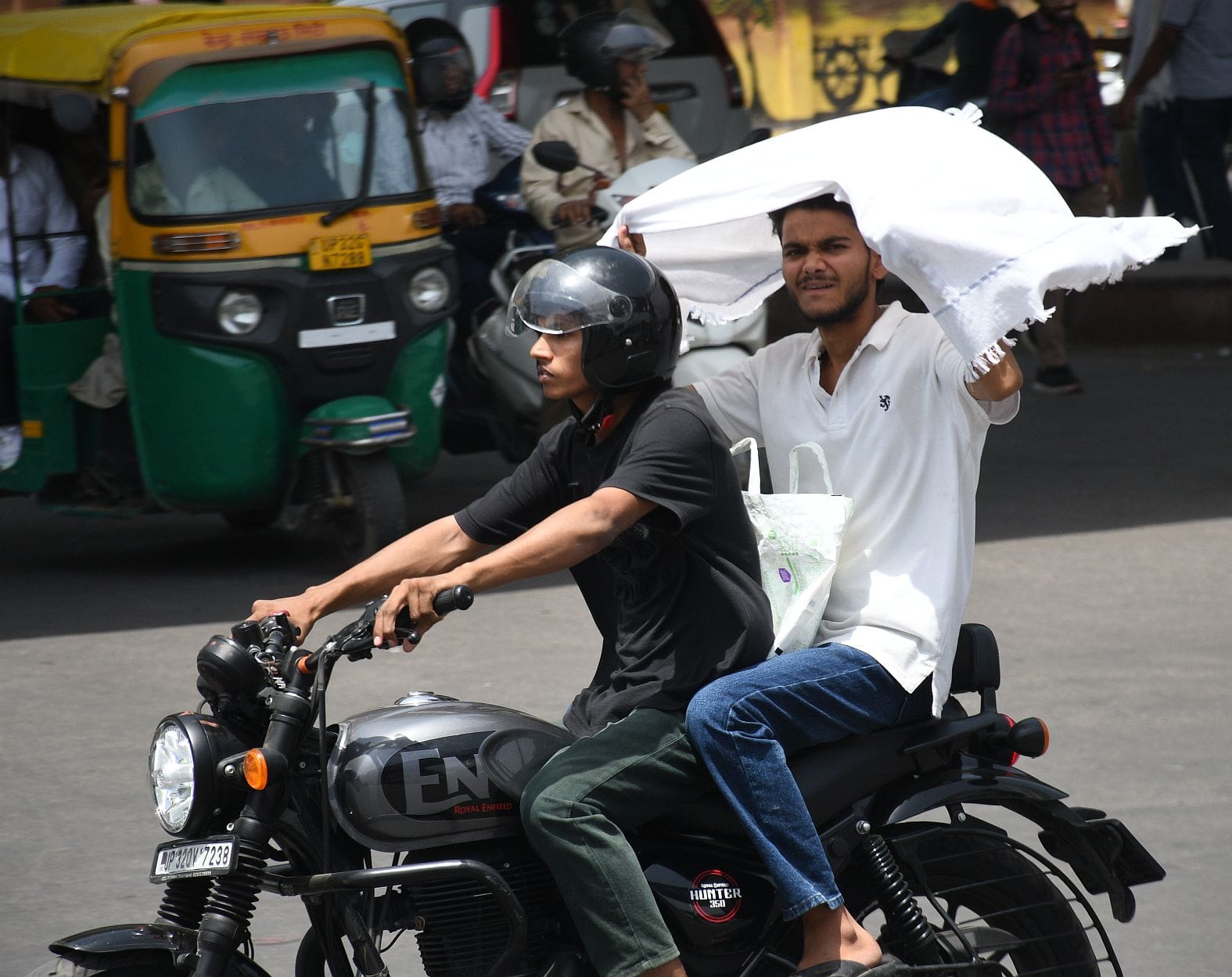 मंगलवार को धूप से बचने की कोशिश करते लोग। 