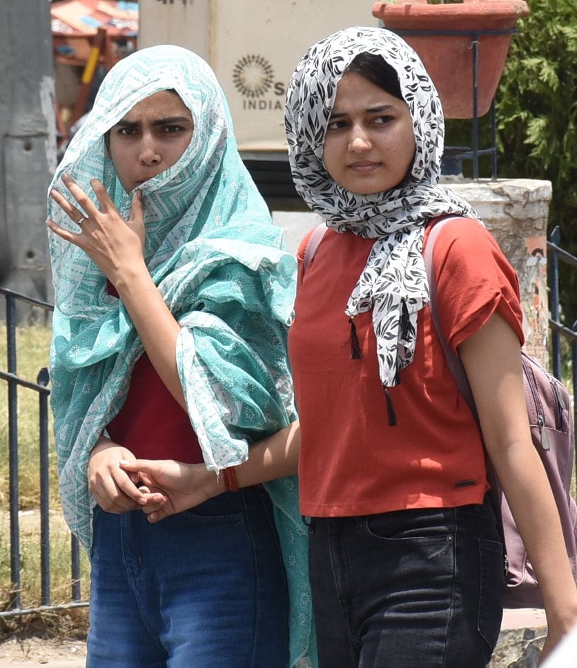मंगलवार को धूप से बचने की कोशिश करते लोग। 