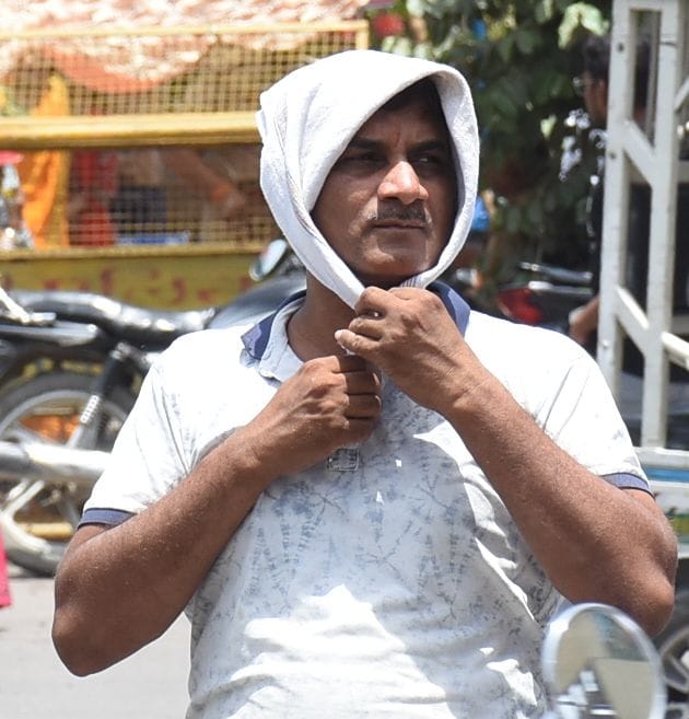 मंगलवार को धूप से बचने की कोशिश करते लोग। 