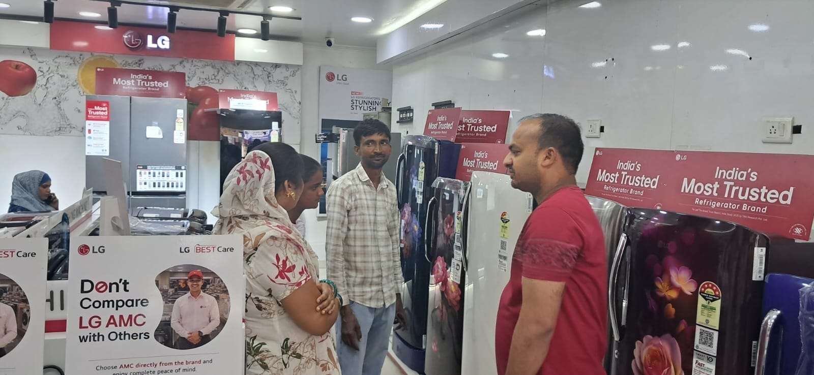 शहर की एक दुकान पर फ्रिज देखतीं महिलाएं। संवाद