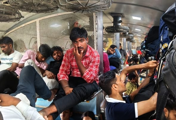 ट्रेन में भीड़ और गर्मी से परेशान यात्री।