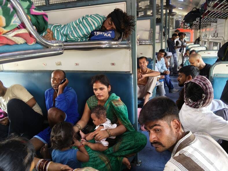ट्रेन में भीड़ और गर्मी से परेशान यात्री।