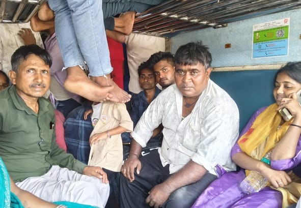 ट्रेन में भीड़ और गर्मी से परेशान यात्री।
