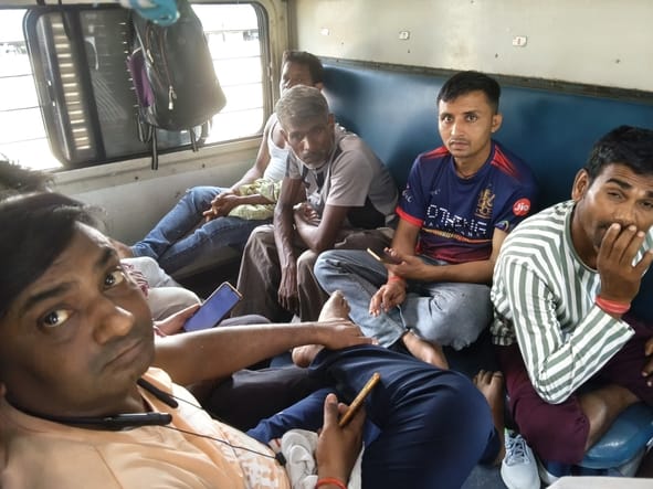 ट्रेन में भीड़ और गर्मी से परेशान यात्री।
