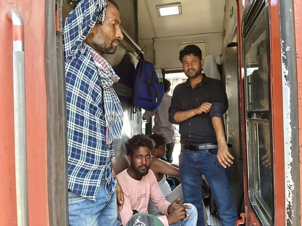 ट्रेन में भीड़ और गर्मी से परेशान यात्री।