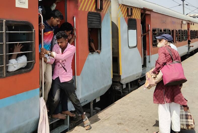 ट्रेन में भीड़ और गर्मी से परेशान यात्री।