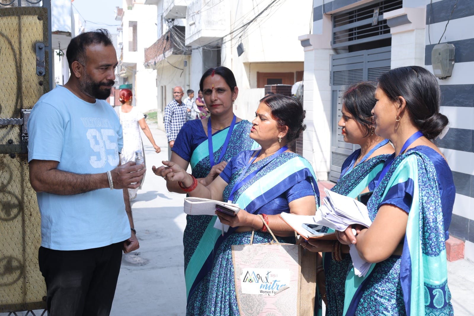 खाली बोतलों से पौधों के लिए बनाए सुरक्षा घेरे को दिखातीं महिलाएं। स्वयं खाली बोतलों से पौधों के लिए बनाए सुरक्षा घेरे को दिखातीं महिलाएं। स्वयं