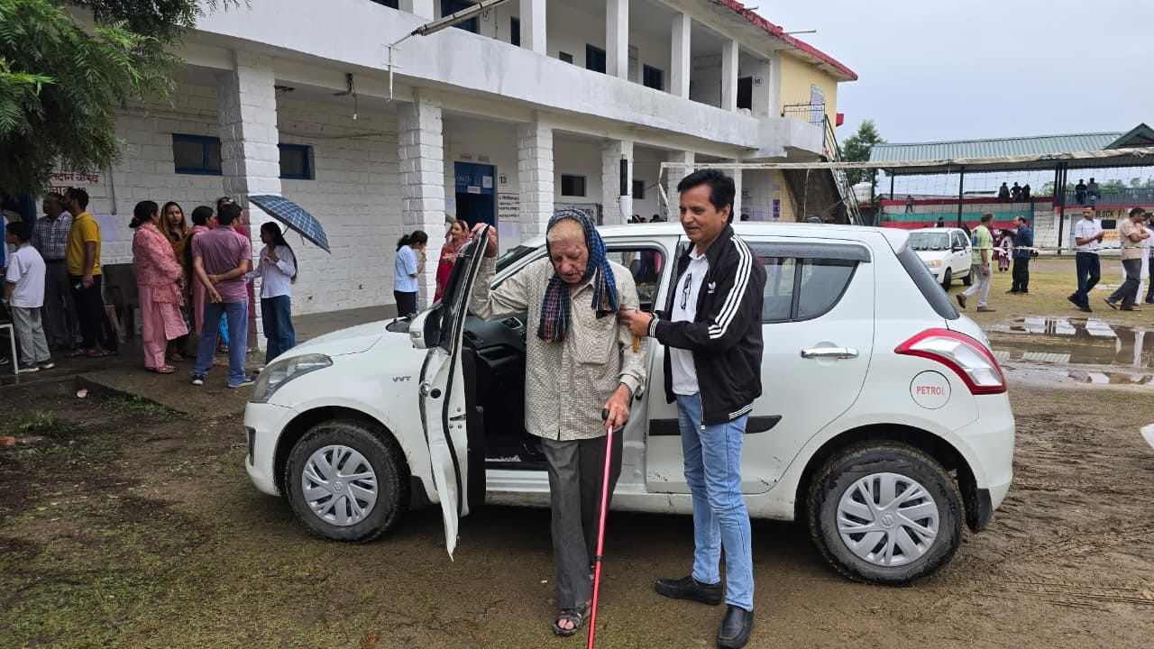 बारिश के दौरान भकेड़ा मतदान केंद्र में कतार में खड़े मतदाता। संवाद बारिश के दौरान भकेड़ा मतदान केंद्र में कतार में खड़े मतदाता। संवाद