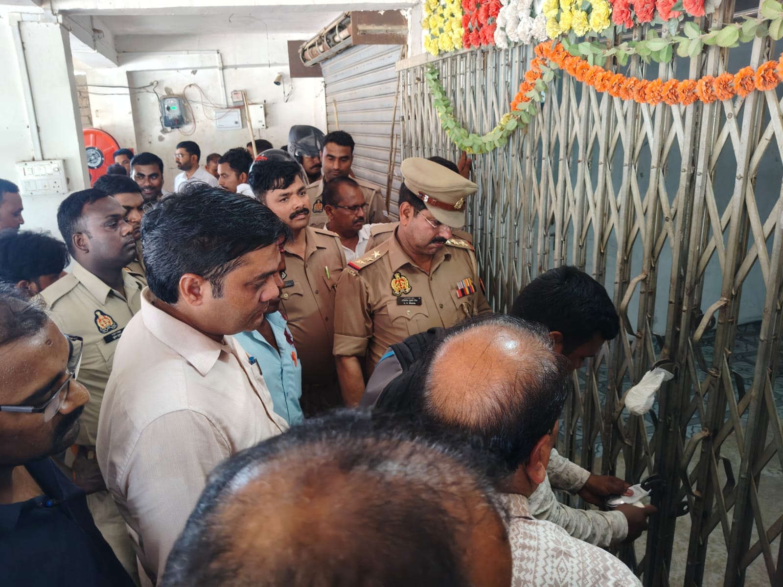 कोन में प्रसूता की मौत के बाद निजी अस्पताल क़ो सील करती टीम और घटना के बाद जुटी भीड़।