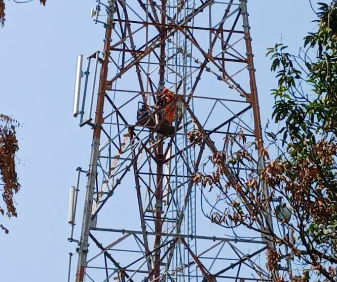 मोबाइल टावर पर बेटे संग चढ़ी महिला और नीचे खड़े लोग। - संवाद