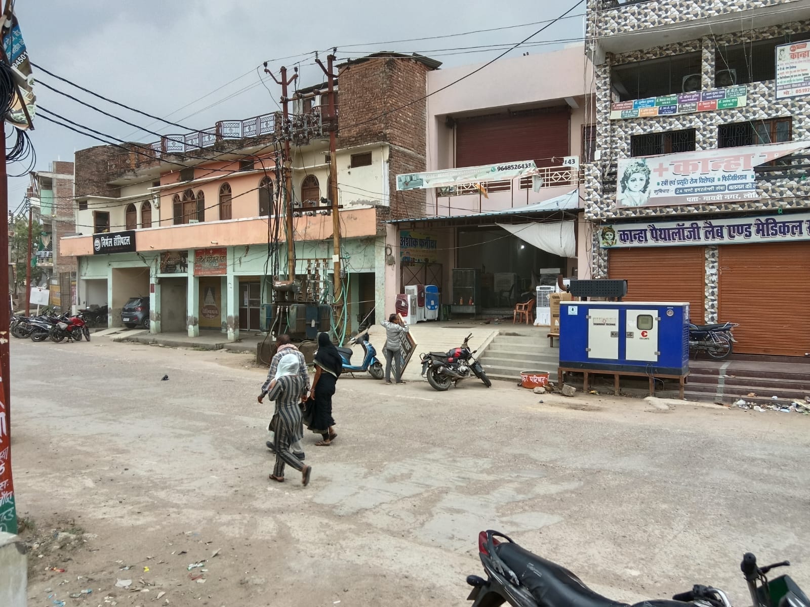 फोटो - 14 नरैनी में बारिश की बीच सड़क से गुजरती महिला। संवाद
