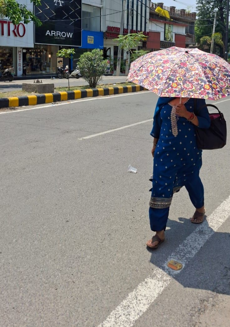 नागरिक अस्पताल में धूप से बचने के लिए छतरी लेकर जाती बच्चियां। संवाद