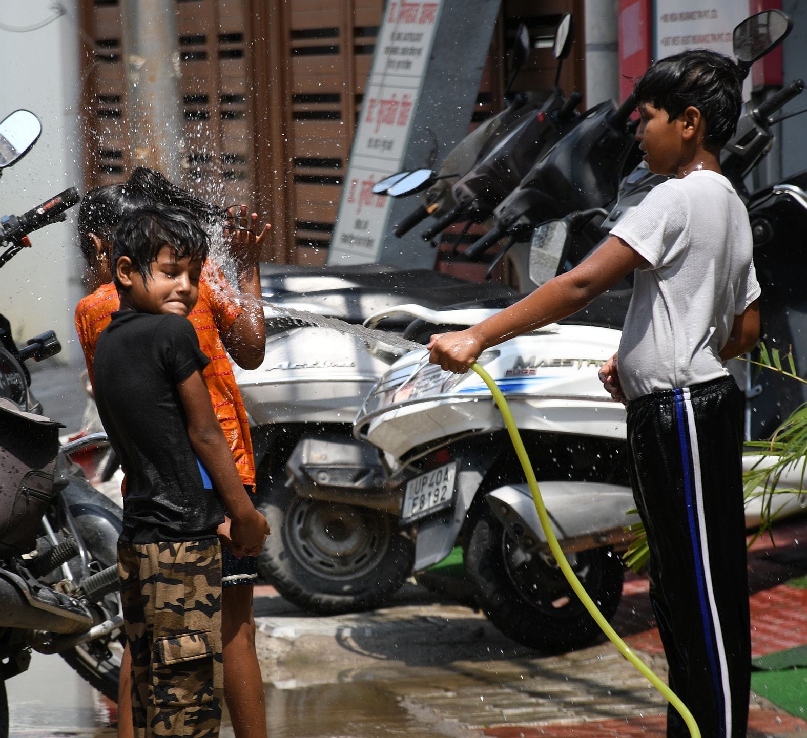 गर्मी से बचाव के लिए पानी से खेलते बच्चे। गर्मी से बचाव के लिए पानी से खेलते बच्चे।