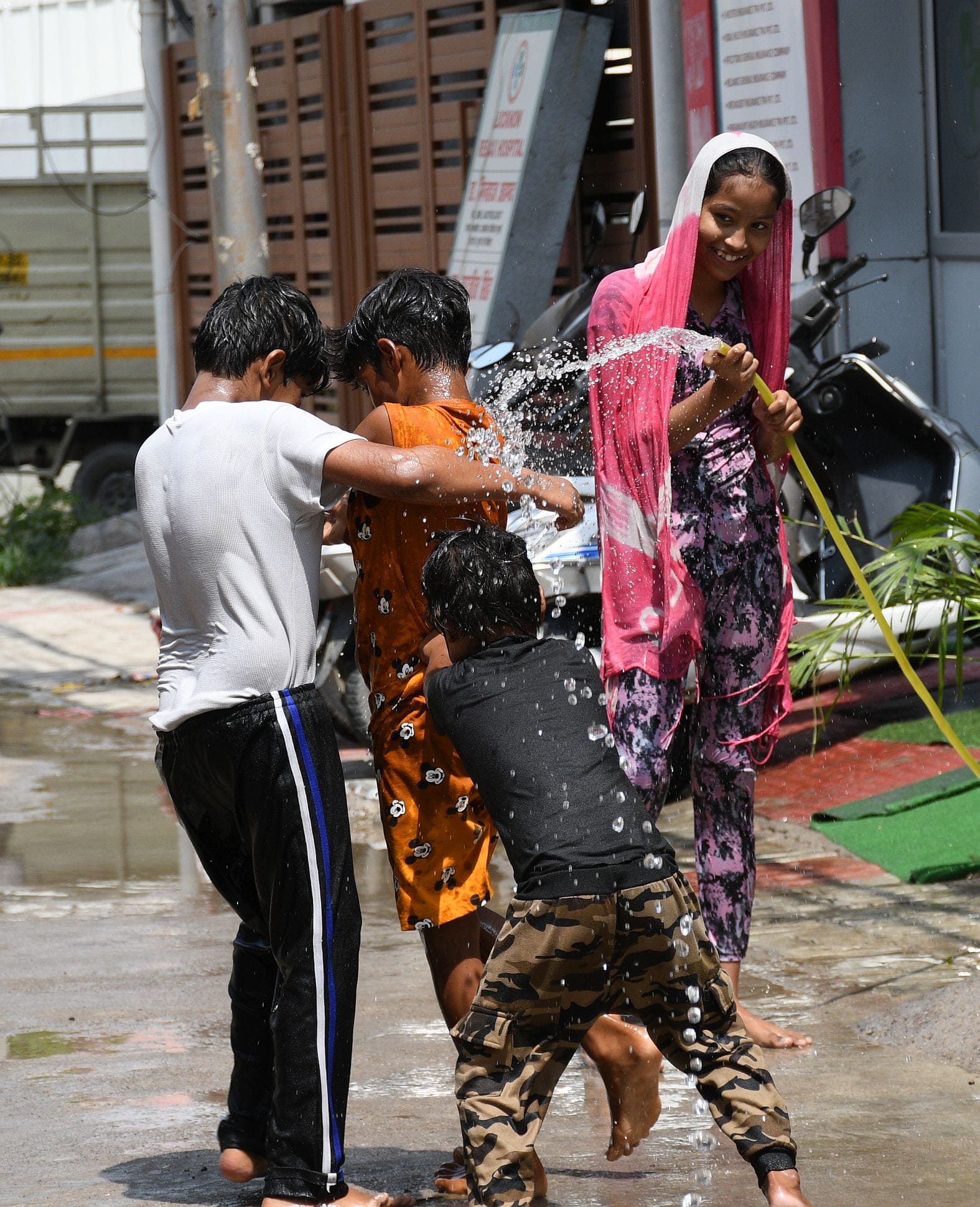गर्मी से बचाव के लिए पानी से खेलते बच्चे। गर्मी से बचाव के लिए पानी से खेलते बच्चे।