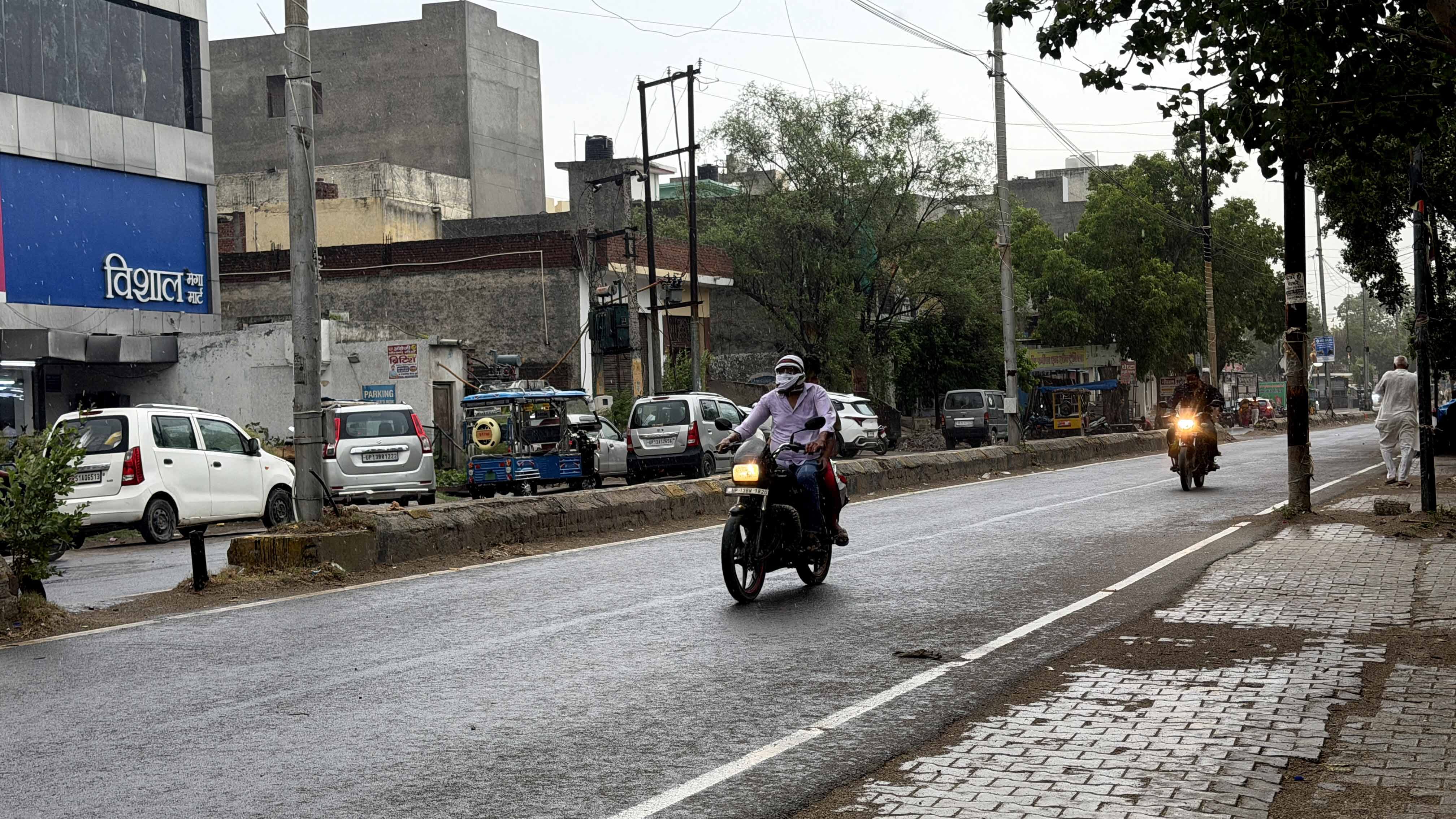 नगर के शनि देव मंदिर मार्ग पर बारिश के बीच जाते लोग। संवाद नगर के शनि देव मंदिर मार्ग पर बारिश के बीच जाते लोग। संवाद