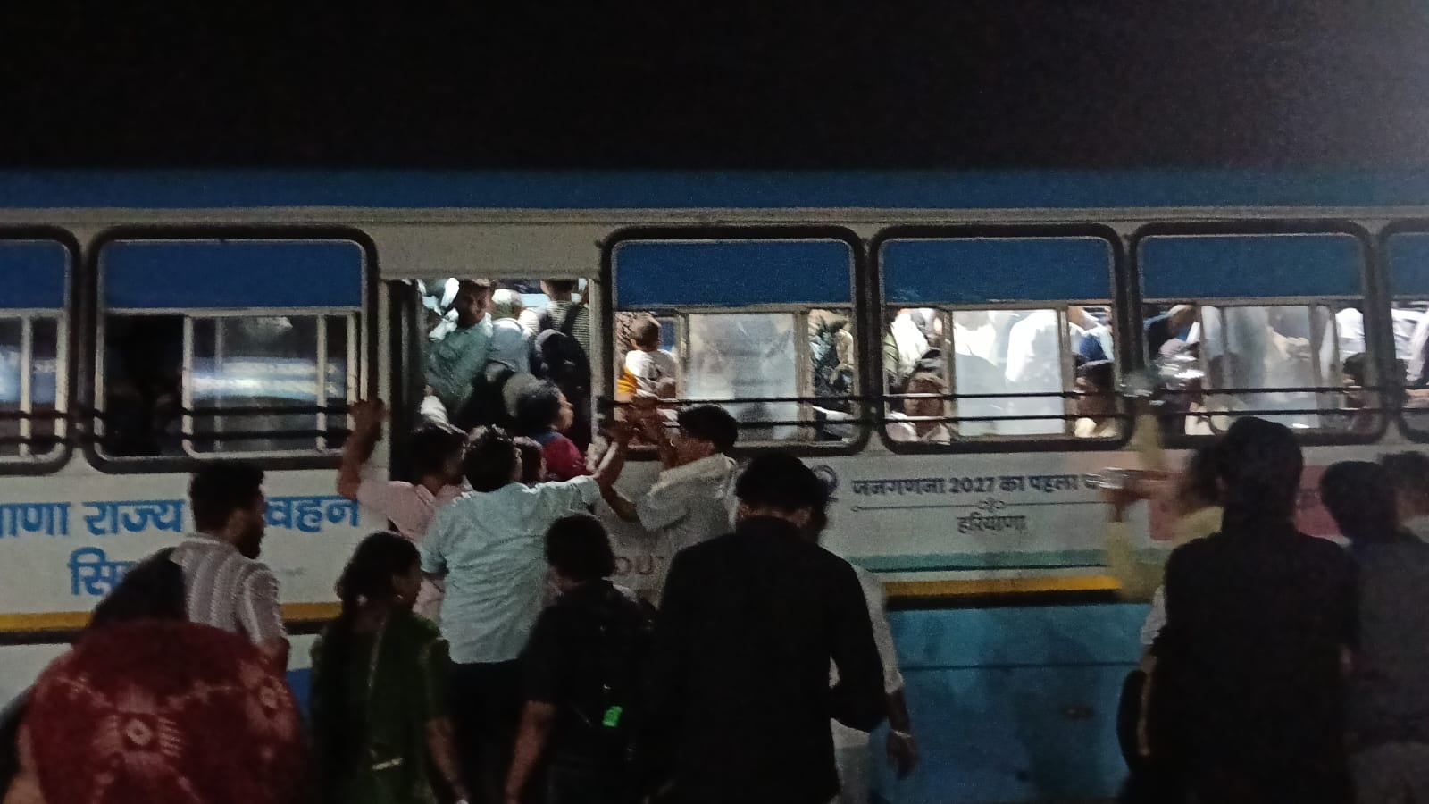 शाम के समय बस देरी से आने पर धक्का मुक्की करते हुए यात्री। संवाद