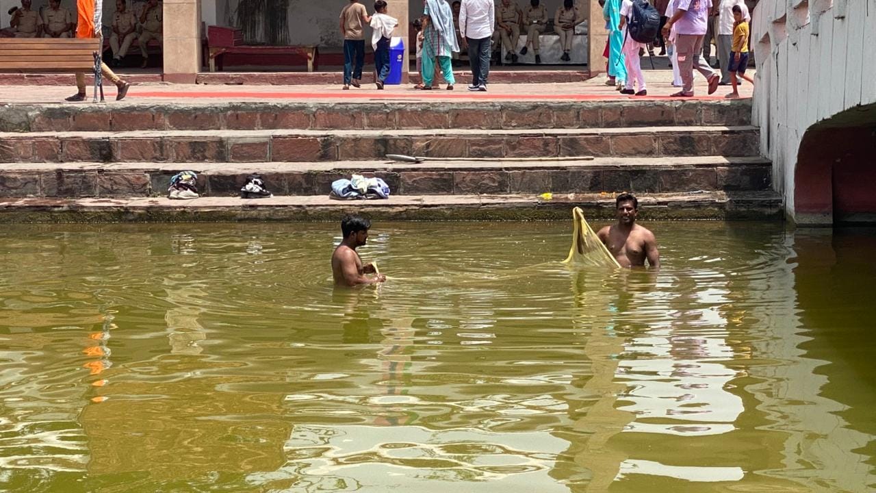 कुरुक्षेत्र। मंदिर के पास की जगह पर जमी काई को बांस की झाड़ू से उतारता सफाई कर्मी। संवाद कुरुक्षेत्र। मंदिर के पास की जगह पर जमी काई को बांस की झाड़ू से उतारता सफाई कर्मी। संवाद