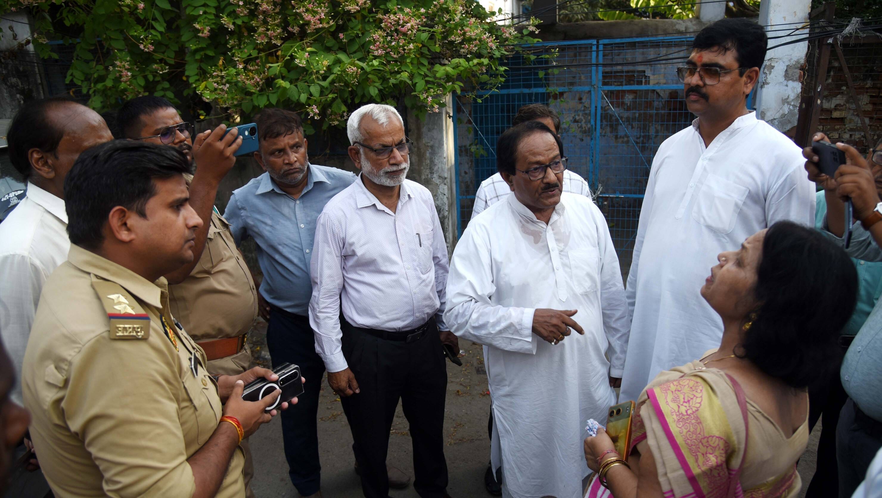 स्कूल के बाहर खड़े प्रबंधन के लोग और शिक्षक।