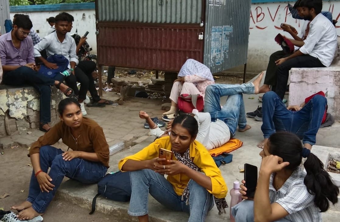 सड़क किनारे पन्नी डालकर नींद पूरी करते अभ्यर्थी। संवाद