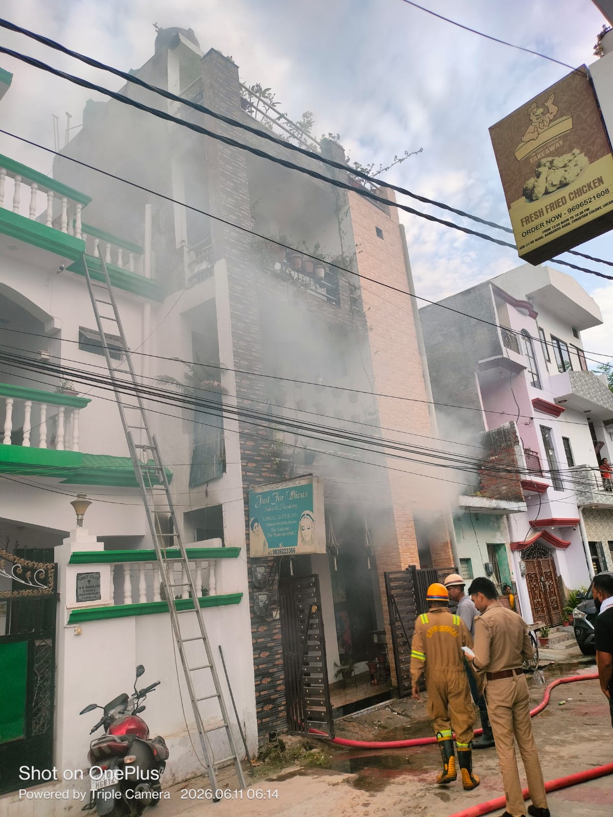 आग बुझाते फायरकर्मी और मकान से नीचे उतरे फंसे युवक।
