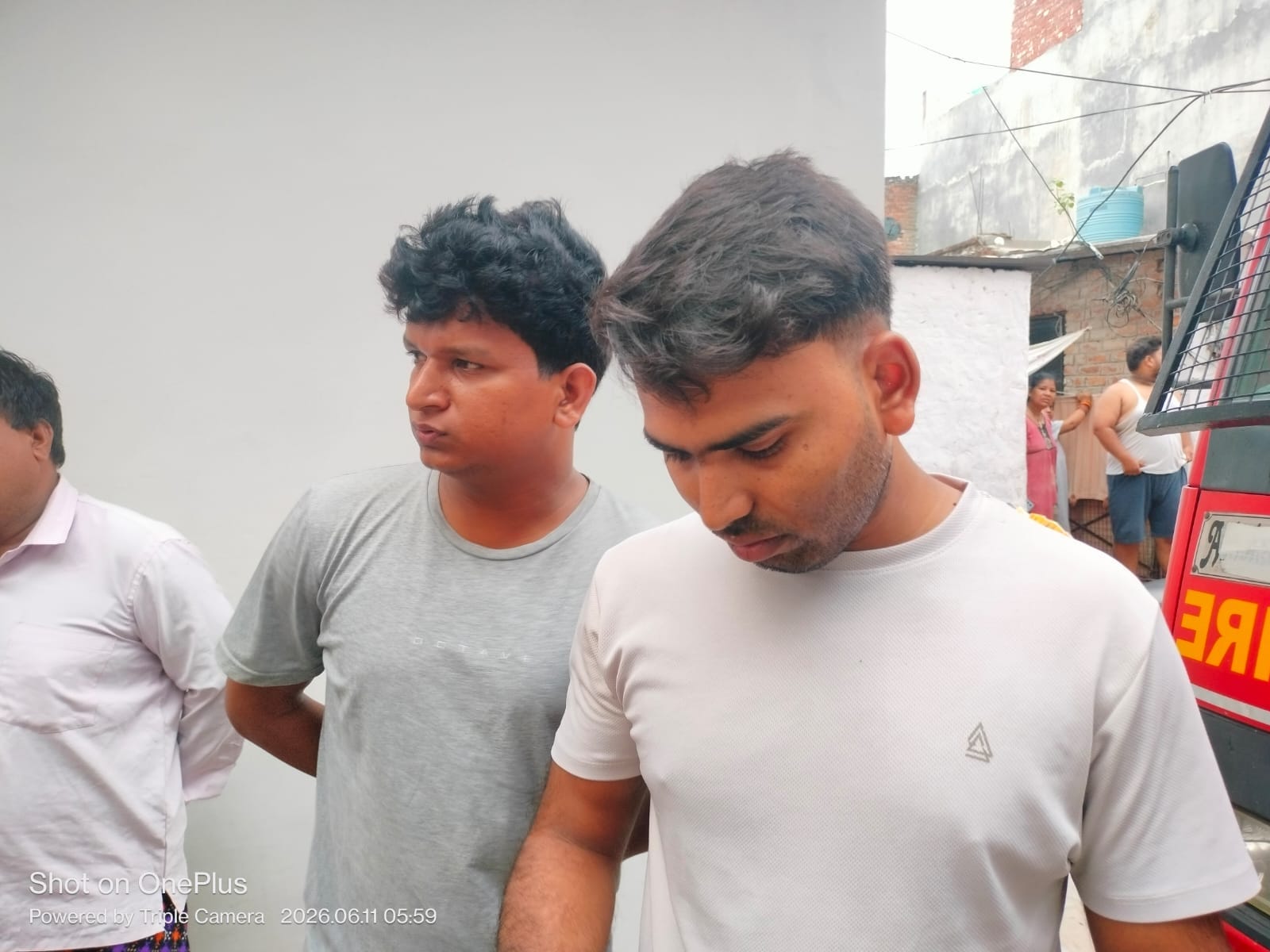 आग बुझाते फायरकर्मी और मकान से नीचे उतरे फंसे युवक।