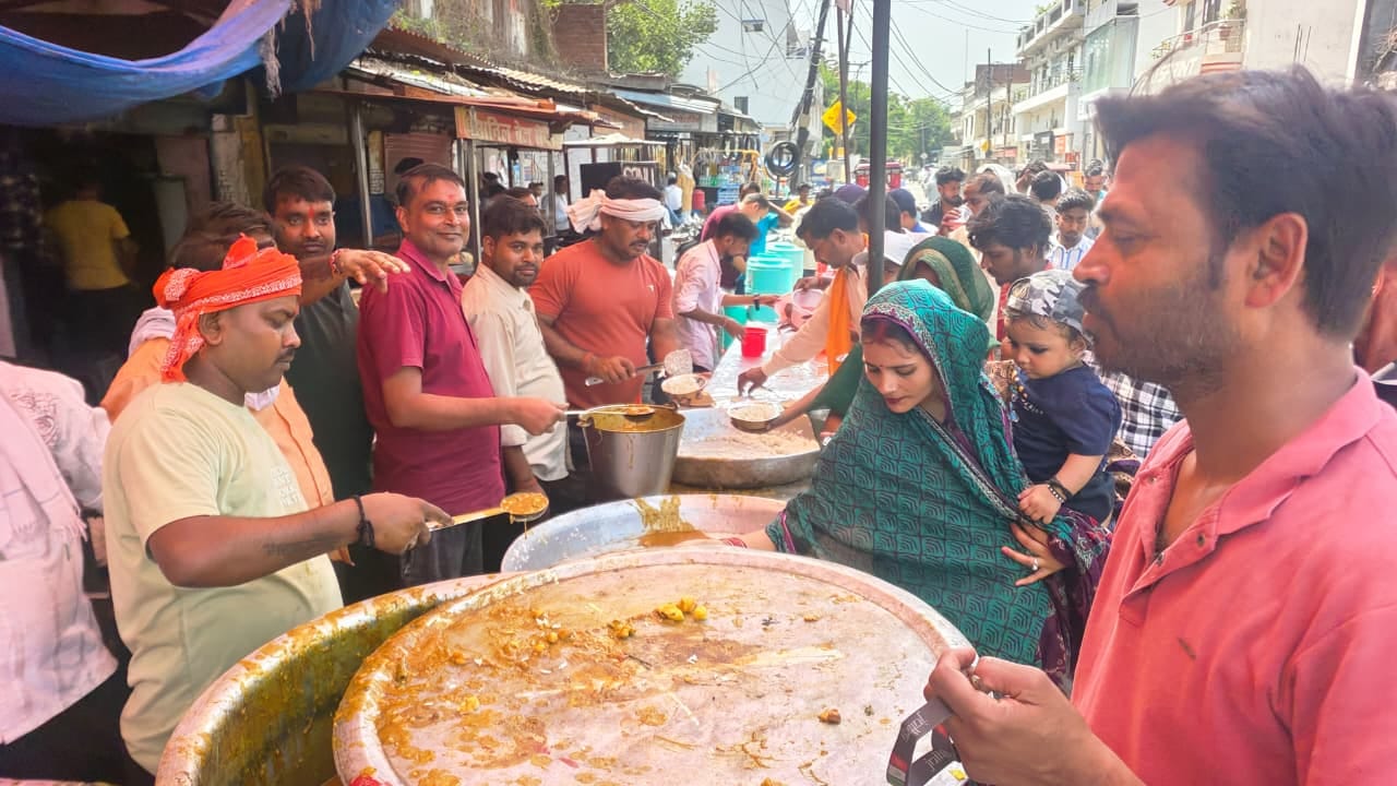 बस स्टेशन रोड पर भंडारे में लोगों को प्रसाद बांटते श्रद्धालु। संवाद