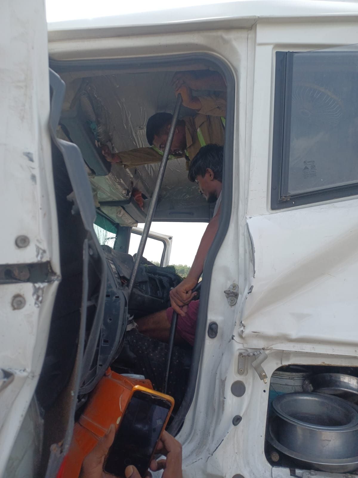 ट्रक का केबिन काटकर चालक को निकालते दमकल कर्मी। ट्रक का केबिन काटकर चालक को निकालते दमकल कर्मी।
