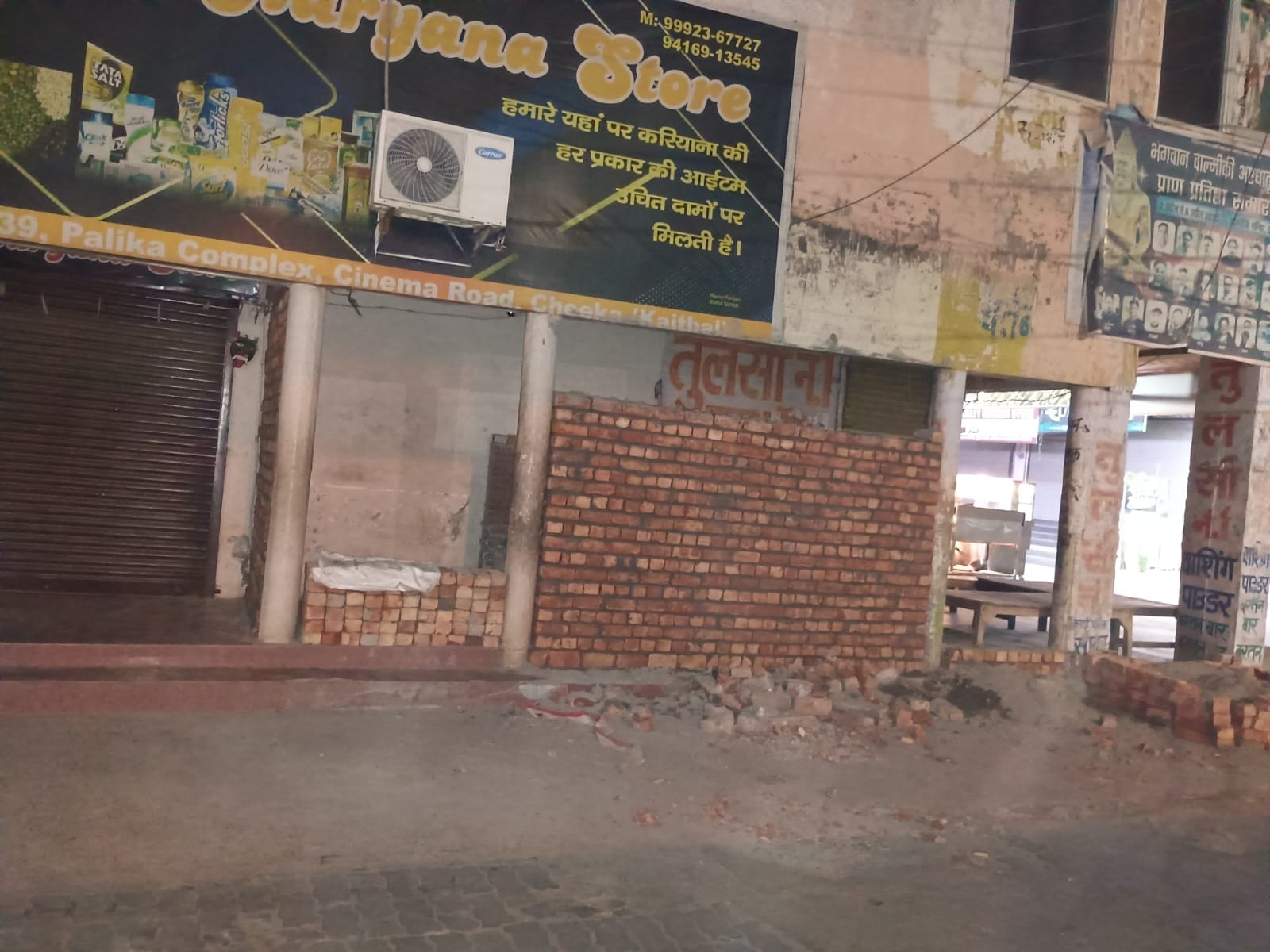 दुकान के बाहर बरामदे में निकाली गई दीवार का दृश्य। दुकान के बाहर बरामदे में निकाली गई दीवार का दृश्य।