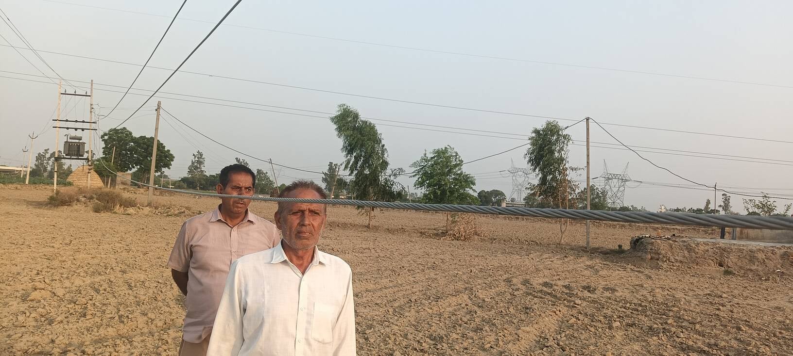 20 ढांड 01 खेतों में जमीन के करीब लटकी बिजली की तारें दिखाते हुए किसान। 20 ढांड 01 खेतों में जमीन के करीब लटकी बिजली की तारें दिखाते हुए किसान।