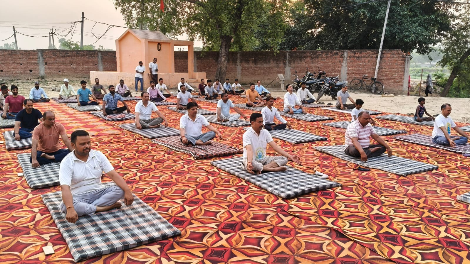 सरूरपुर। योग दिवस के मौके पर कम पब्लिक स्कूल में योग करते शिक्षक। स्वयं