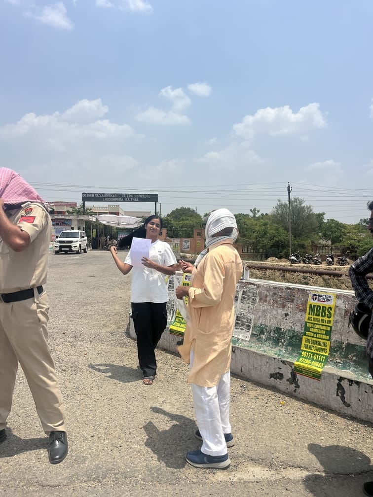 परीक्षा केंद्र से बच्चे के बाहर आने के इंतजार में खेतों में लेटे और बैठे हुए अभिभावक। संवाद परीक्षा केंद्र से बच्चे के बाहर आने के इंतजार में खेतों में लेटे और बैठे हुए अभिभावक। संवाद