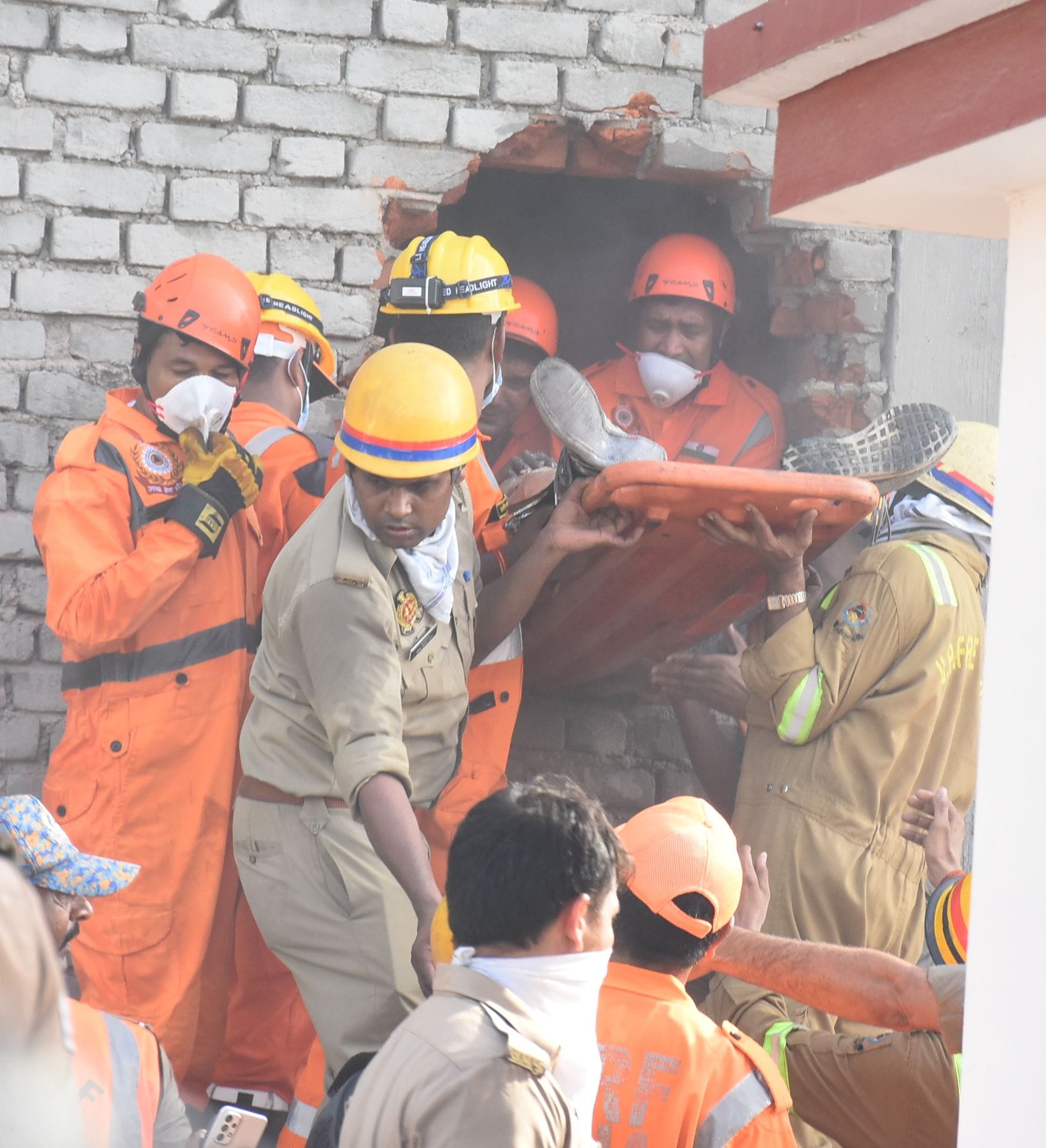 बिल्डिंग के पीछे की दीवार तोड़कर दमकल और एसडीआरएफ कर्मियों ने निकाले शव। 