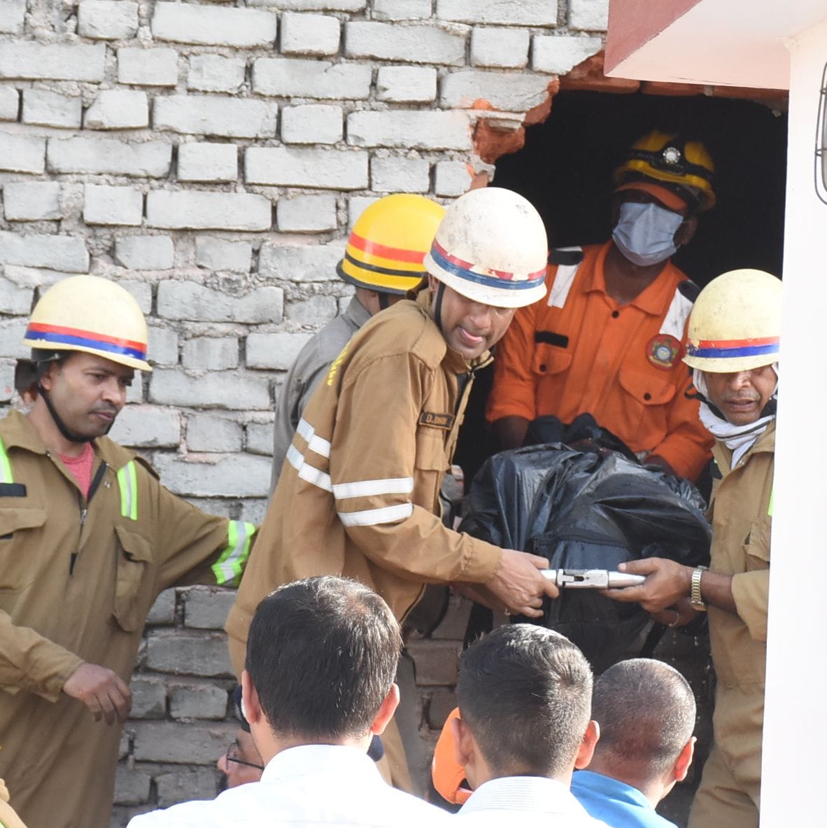 बिल्डिंग के पीछे की दीवार तोड़कर दमकल और एसडीआरएफ कर्मियों ने निकाले शव। 