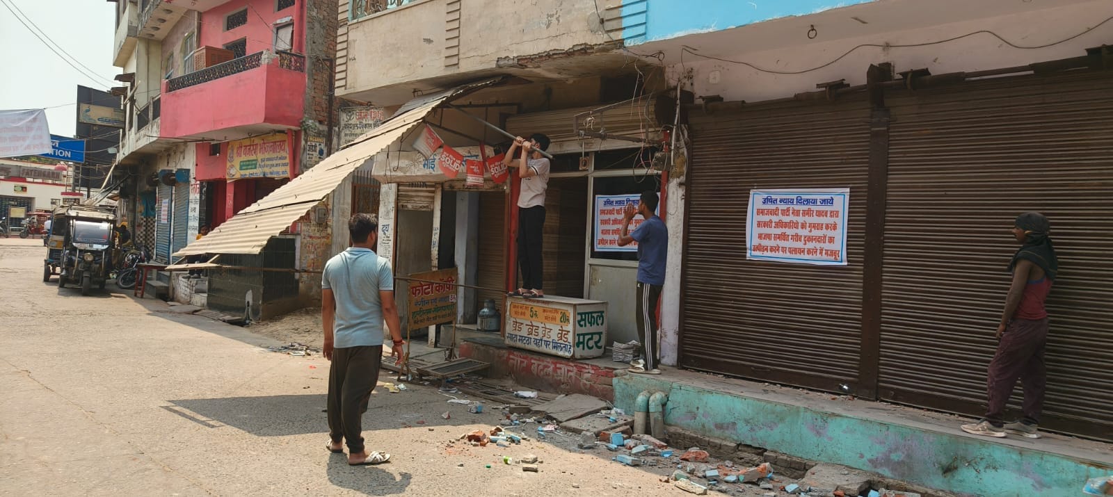 फोटो-39 रेलवे स्टेशन रोड पर दुकानों के बाहर पोस्टर लगाकर न्याय की मांग करतीं महिलाएं। संवाद
