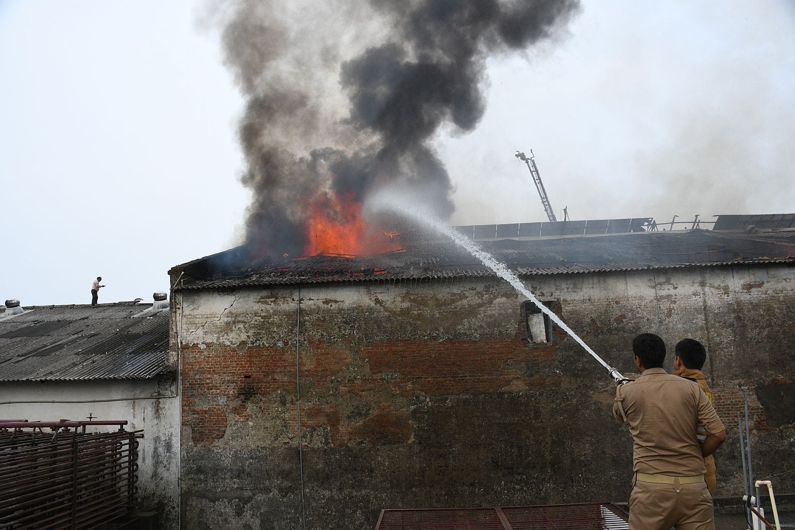 कोल्ड स्टोरेज में लगी आग और मौके पर मौजूद लोग। कोल्ड स्टोरेज में लगी आग और मौके पर मौजूद लोग।